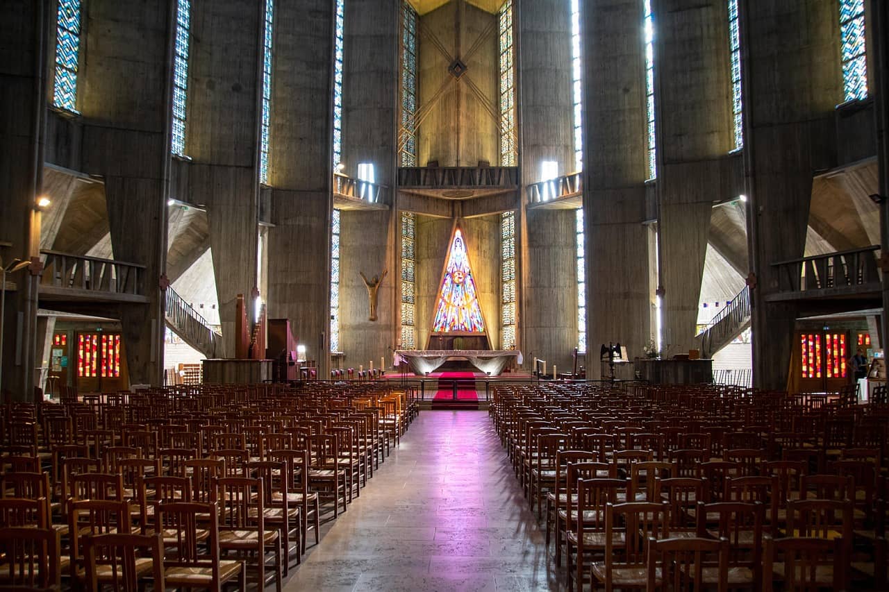 Soaring vaulted sanctuary interior with stained glass